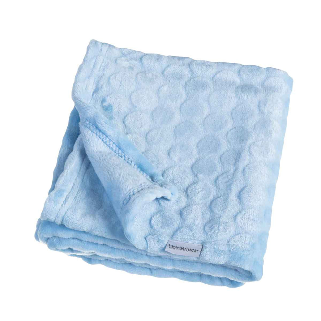 Folded light blue marshmallow textured blanket with a Clair de Lune brand label on a white background