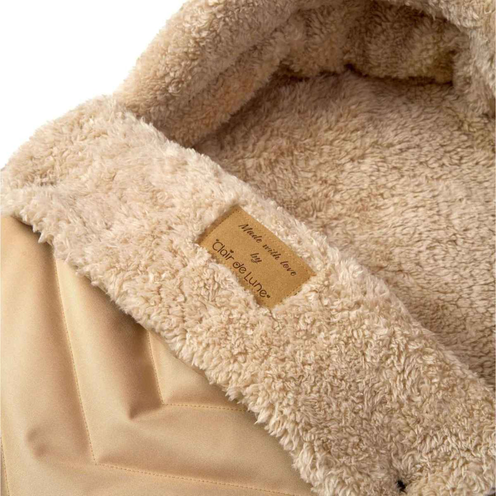 Close-up of beige teddy fleeced footmuff with a Clair de Lune label on product