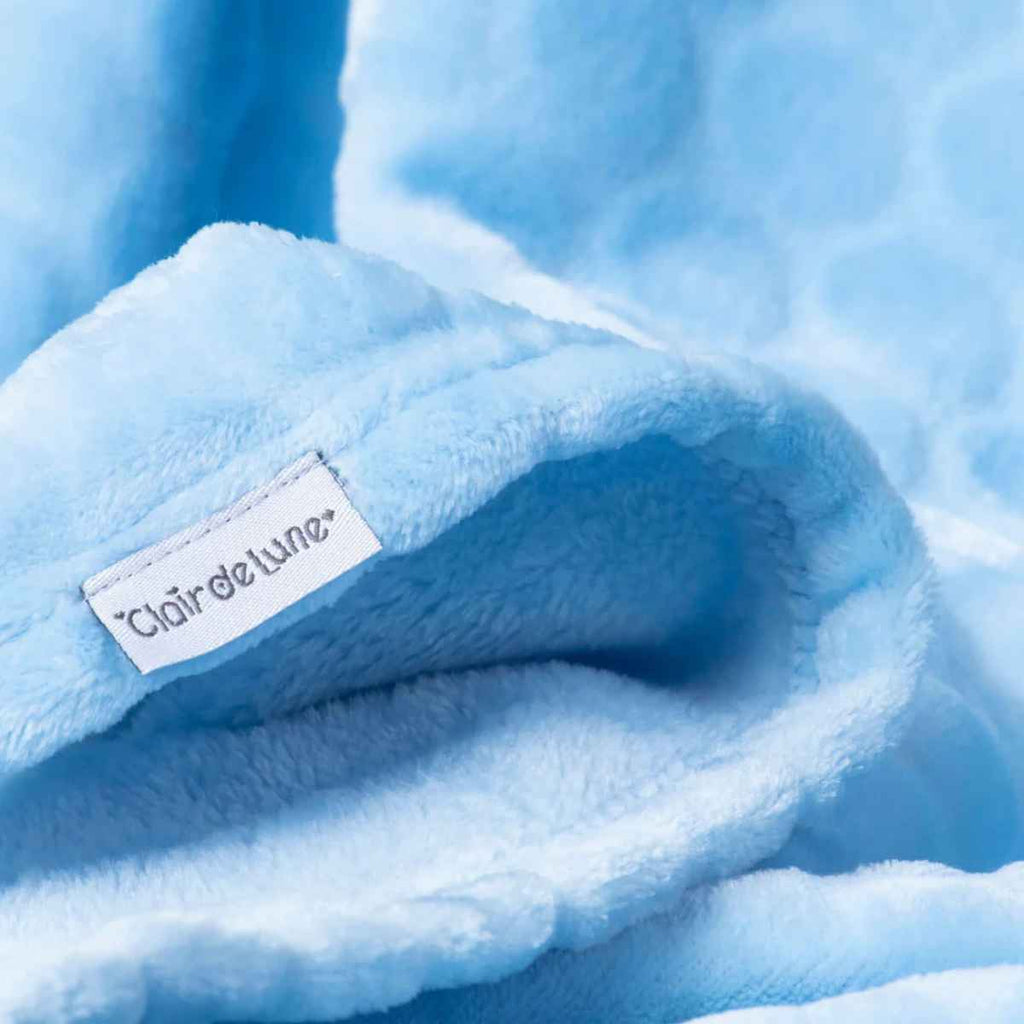 Close-up of a blue marshmallow blanket with a Claire de Lune label.