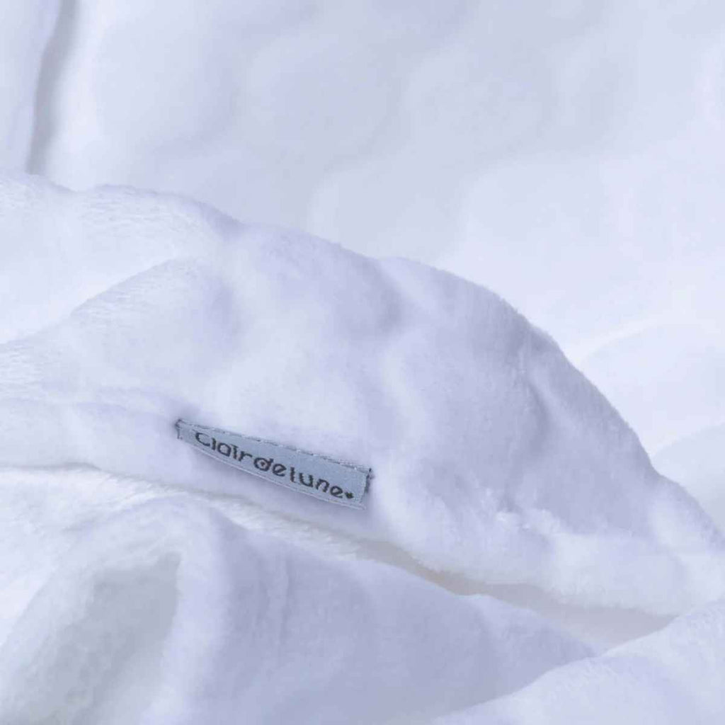 Close-up of a white blanket with a visible Clair de Lune brand label 