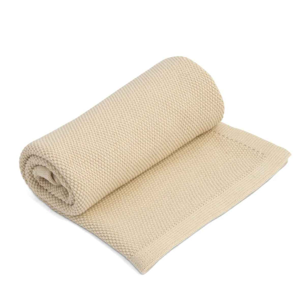 Rolled up cream blanket on a white background
