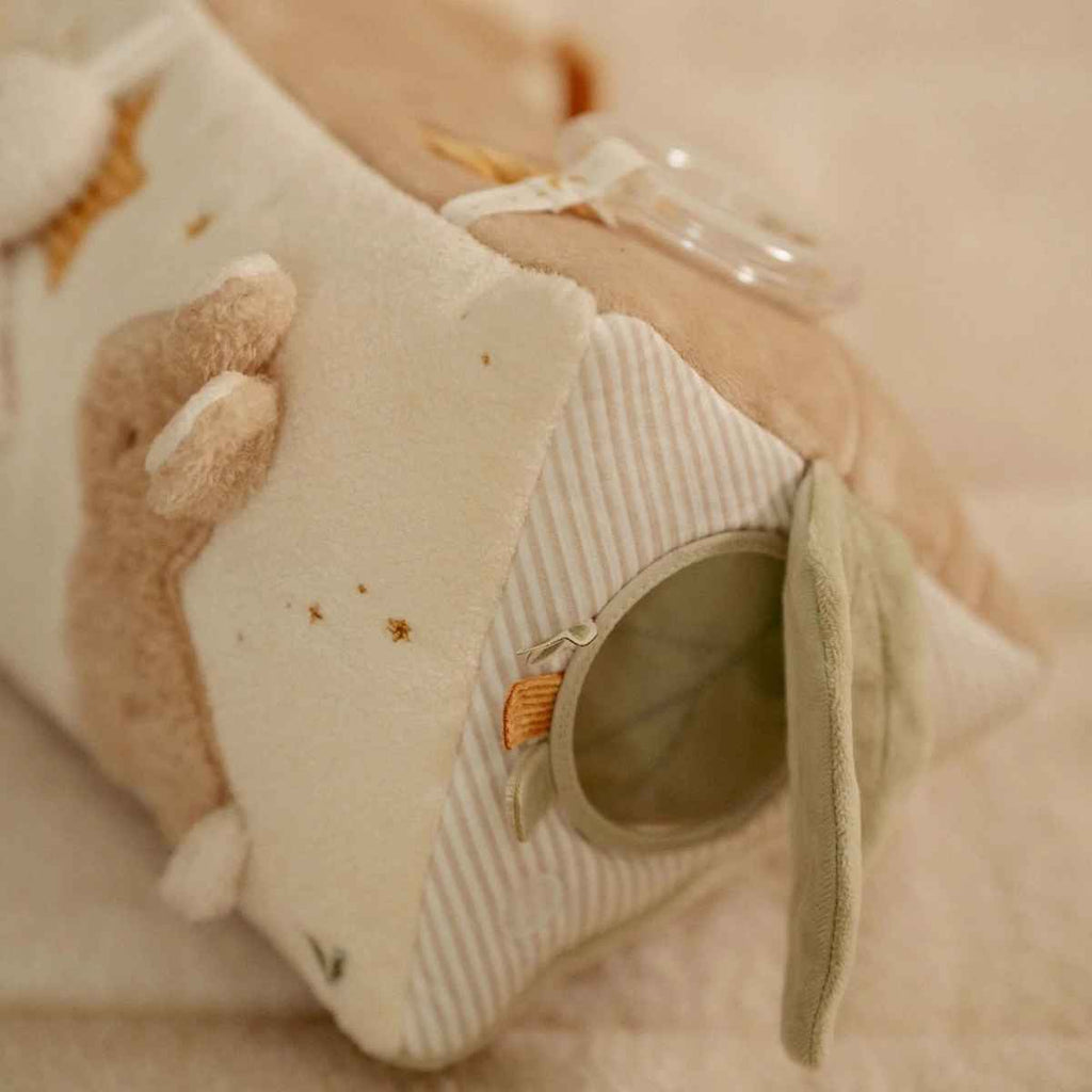 Close-up of a soft toy with a mirror and bunny design on a neutral background.