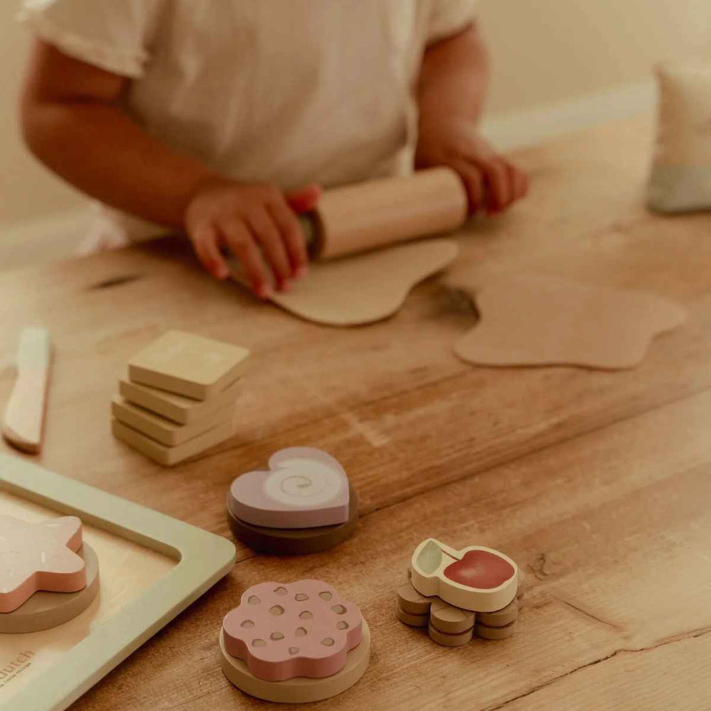 Child playing with wooden toys on a wooden table