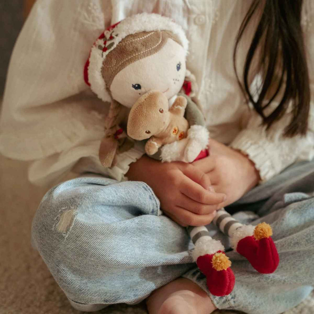 Child holding a plush toy with a soft focus background