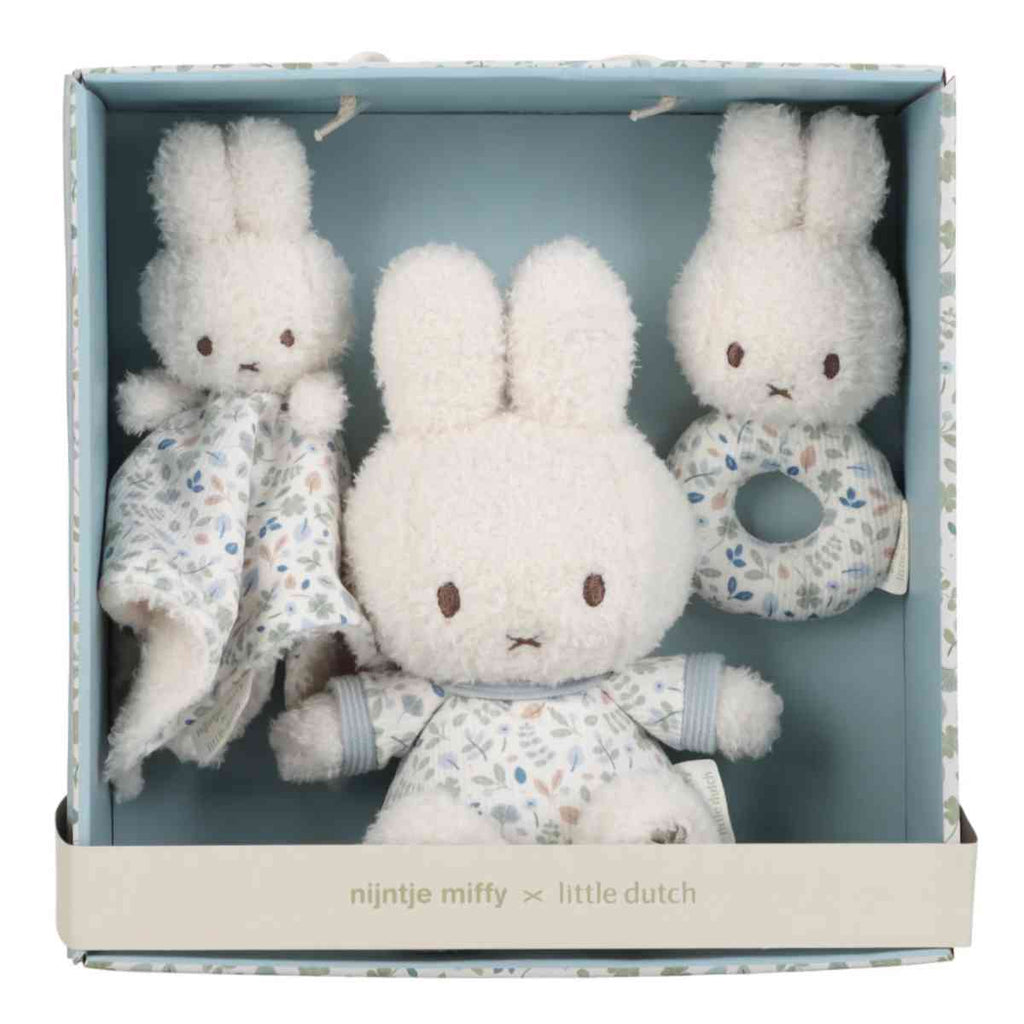 Three bunny plush toys with a flower pattern in a blue gift box.