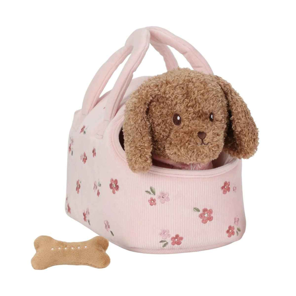 Plush dog toy in a pink floral pet carrier with a bone on a white background