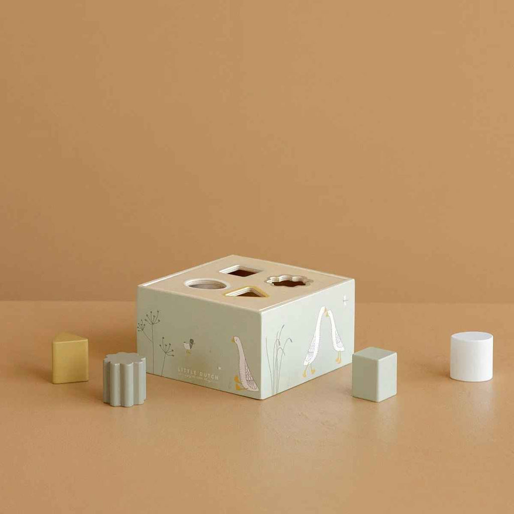 Educational shape sorting toy with blocks on a beige background