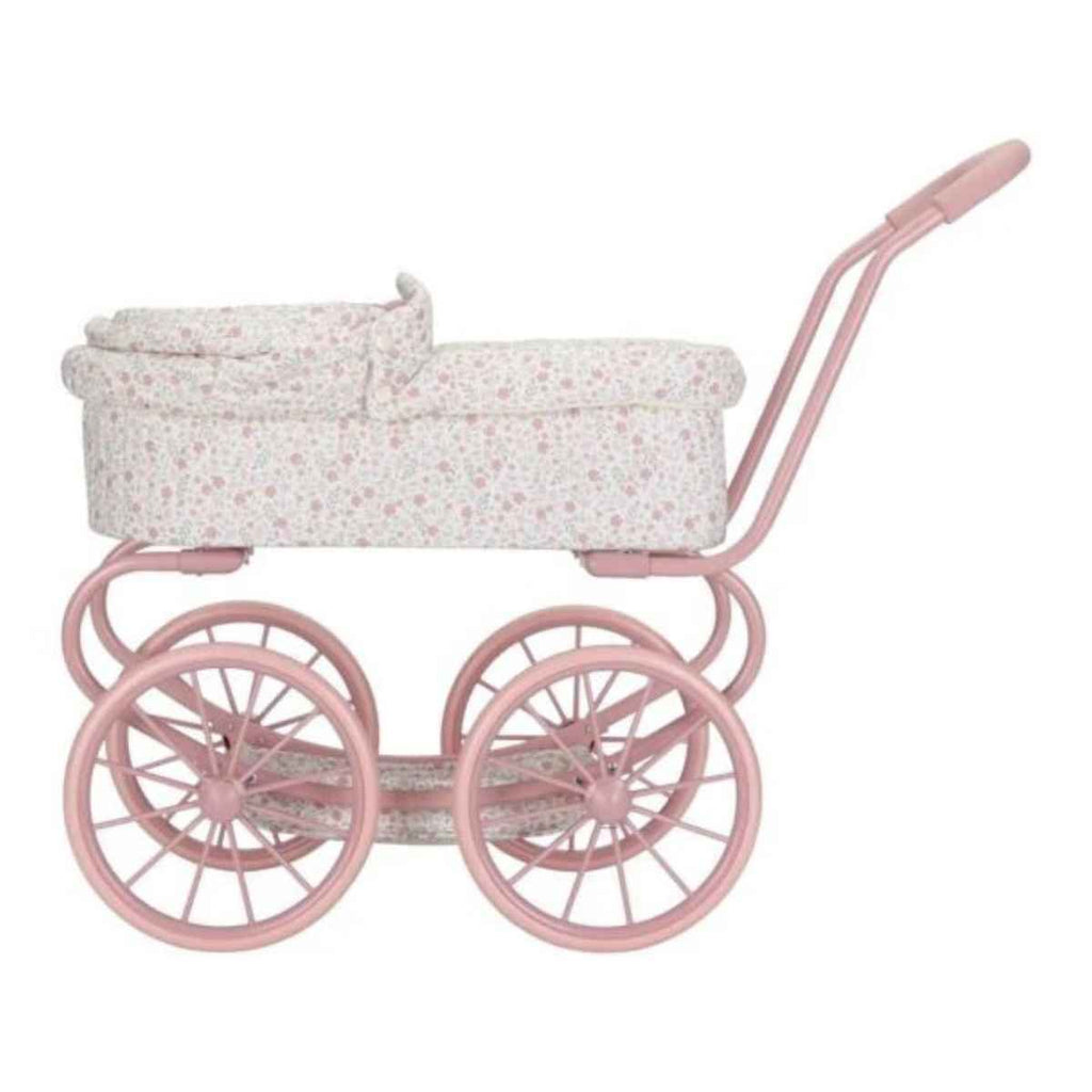Pink vintage-style doll pram with hood down and a floral patterned cover on a white background