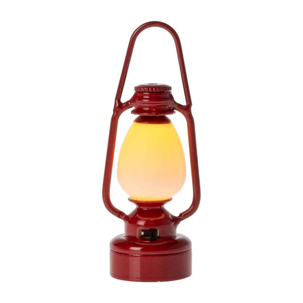 Red lantern-style lamp with a yellow light on a white background