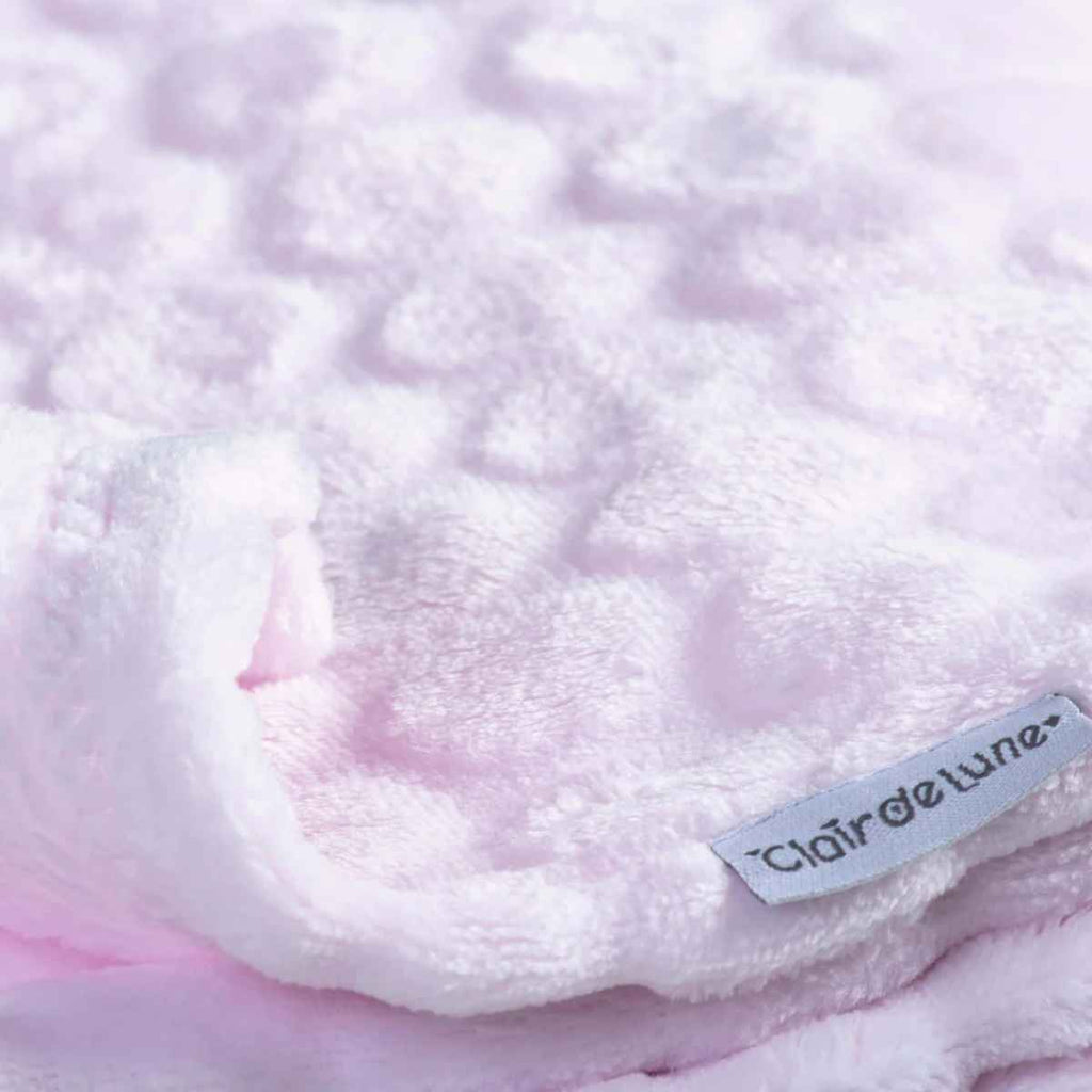 Close-up of a fluffy pink marshmallow blanket with 'Clair de Lune' label.