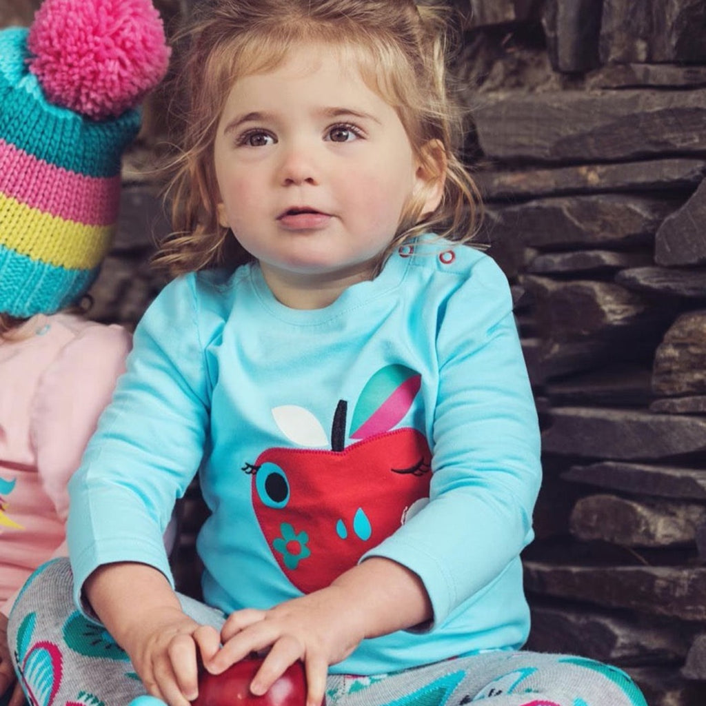 Blade & Rose | Little girl wearing a blue long sleeved top with a smiling apple printed on the front | Chocoloons