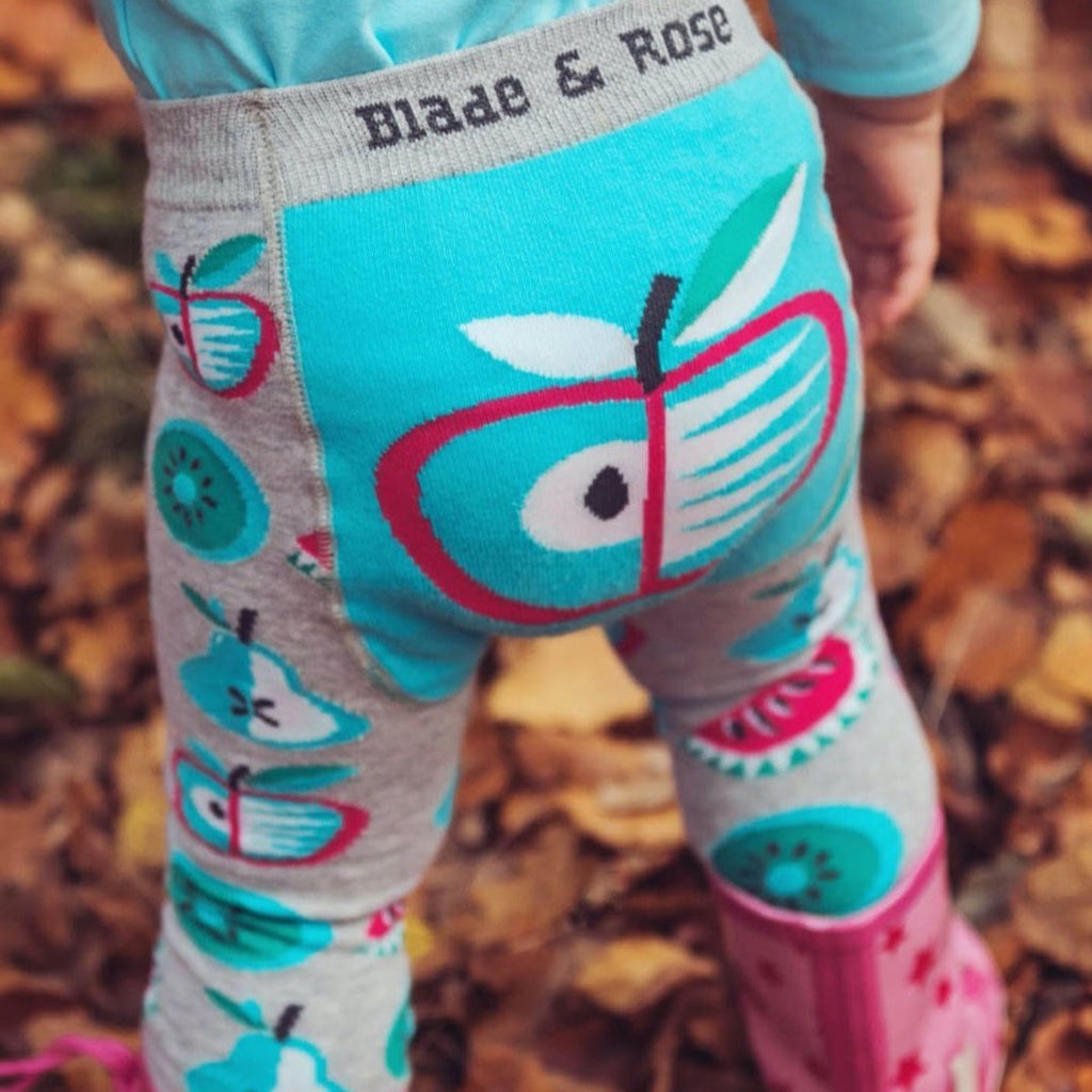 Blade & Rose | Baby wearing grey and blue leggings with a blue, pink and green apple and kiwi pattern | Chocoloons